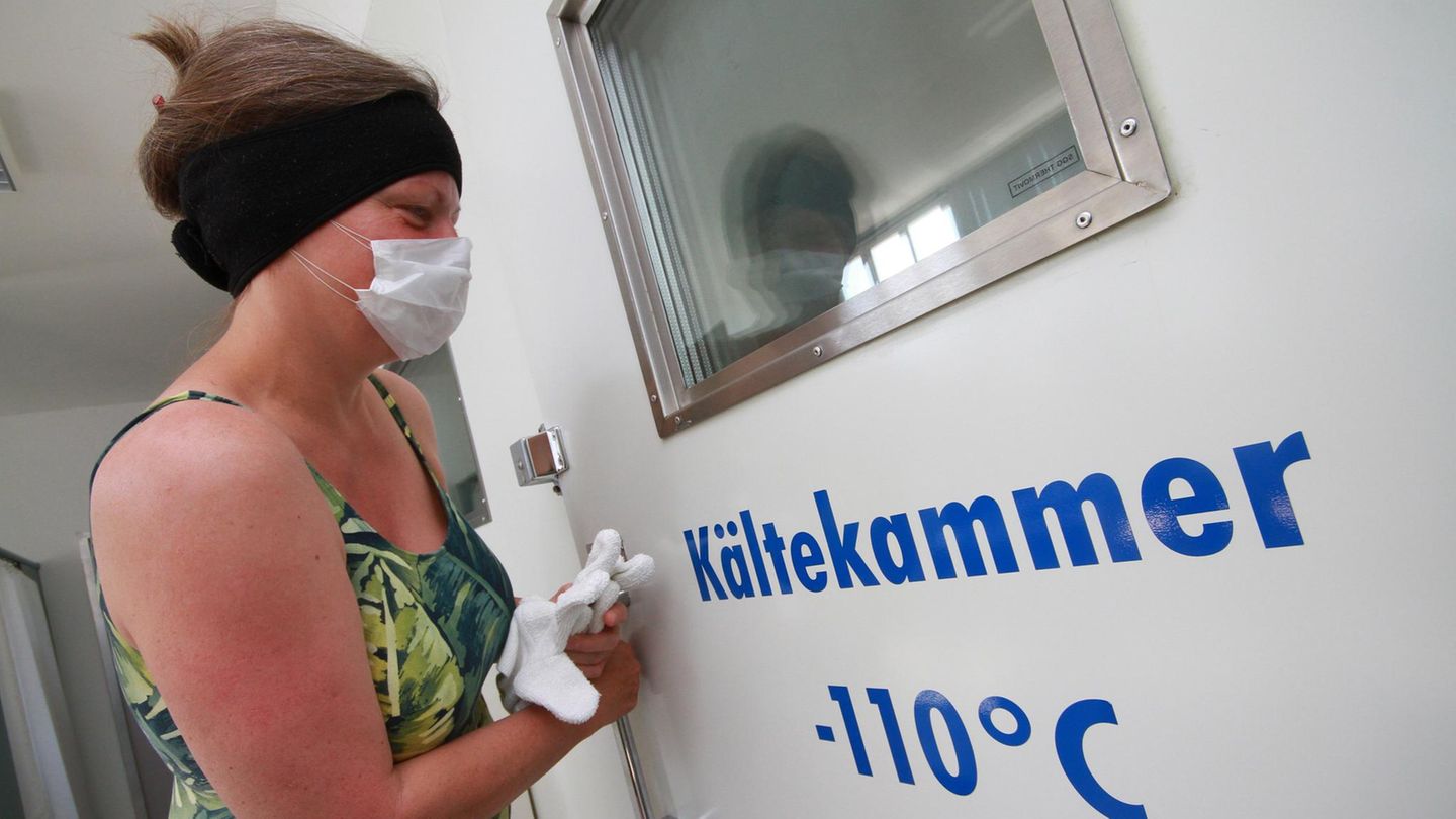 Eine Frau betritt eine Kältetherapiekammer.