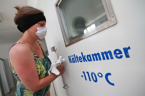 Eine Frau betritt eine Kältetherapiekammer.
