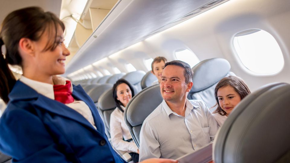 Eine Stewardess lächelt im Flugzeug