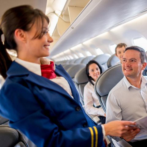 Eine Stewardess lächelt im Flugzeug