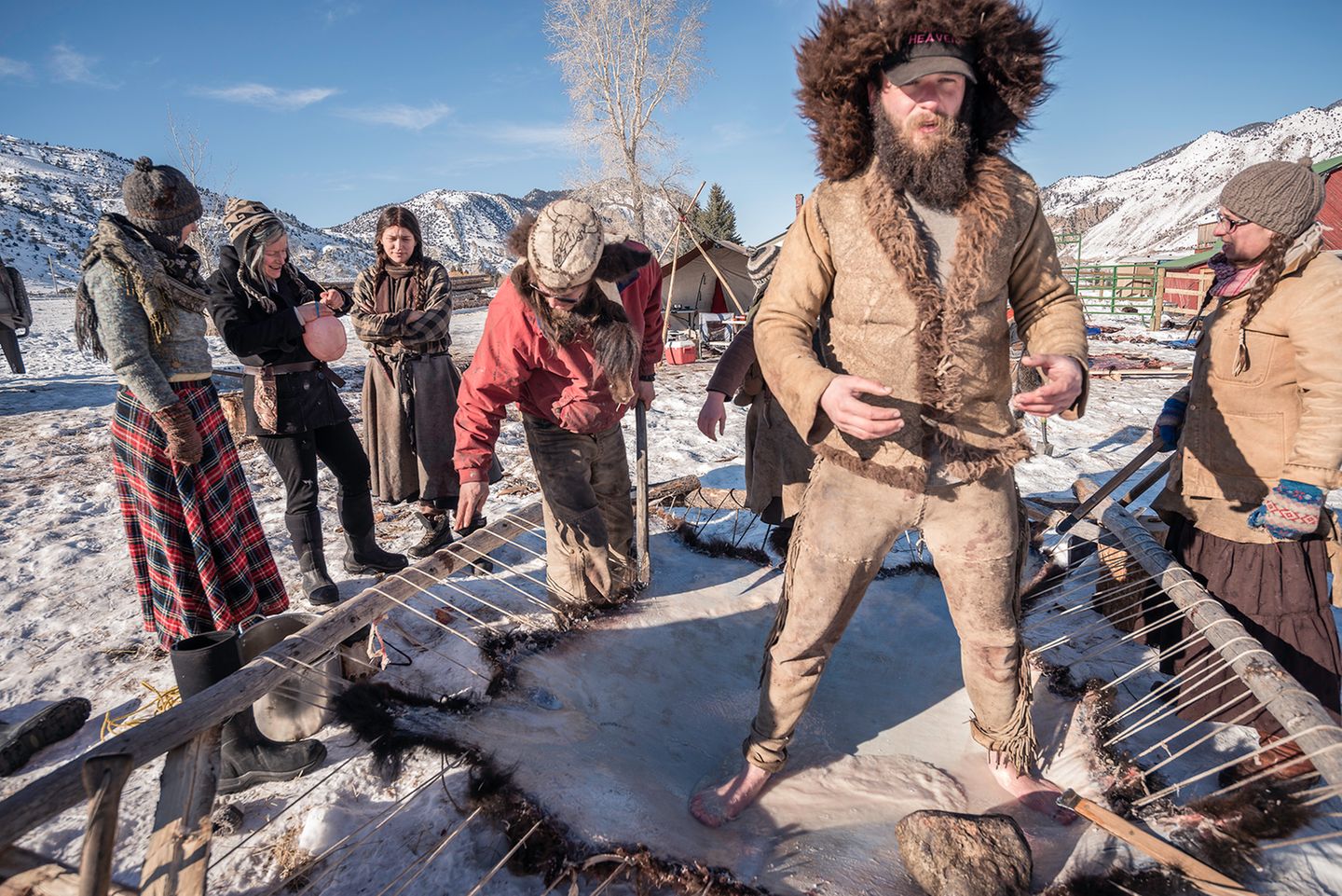 Mit nackten Füßen arbeitet Alex Heathen gekochtes Büffelhirn in das aufgespannte Fell, um es zu gerben.