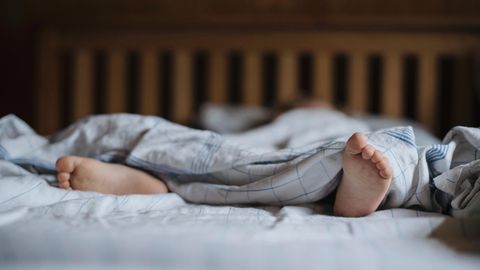 Füße eines schlafenden Kindes im Bett (Symbolbild für Resignation Syndrome in Schweden)