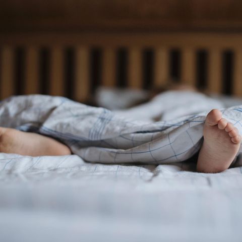 Füße eines schlafenden Kindes im Bett (Symbolbild für Resignation Syndrome in Schweden)