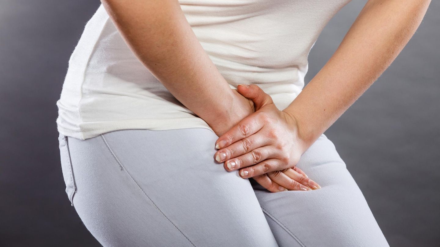 Eine Frau hat Schmerzen und fasst sich an den Bauch.