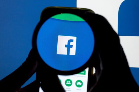 Das Facebook-Logo durch eine Lupe betrachtet