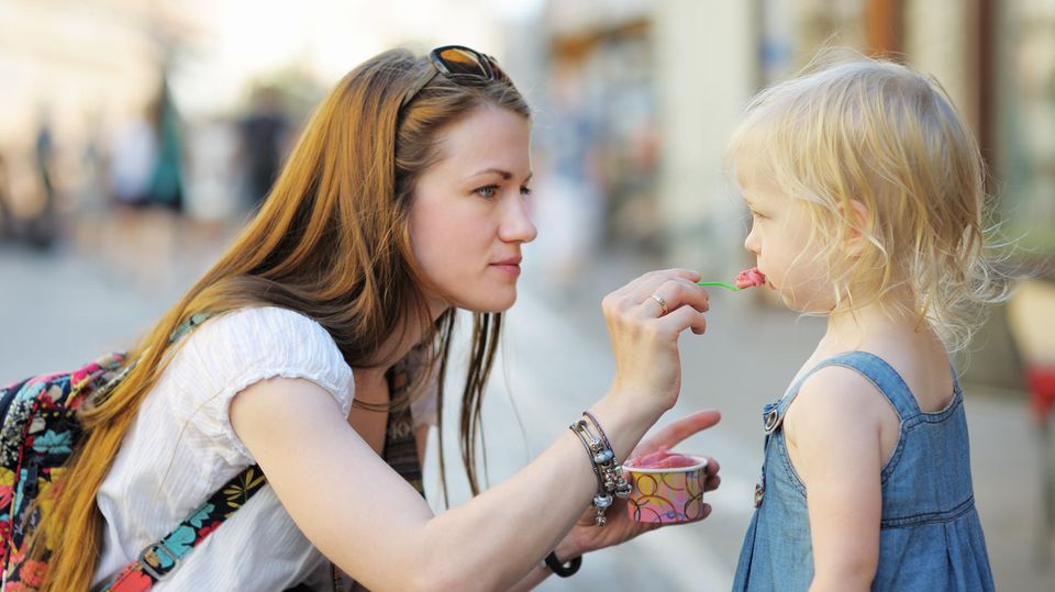 Mutter füttert Tochter mit Eis