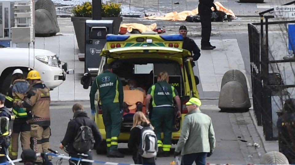 Rettungskräfte kümmern sich nach dem Lkw-Anschlag im Zentrum von Stockholm um eine verletzte Person