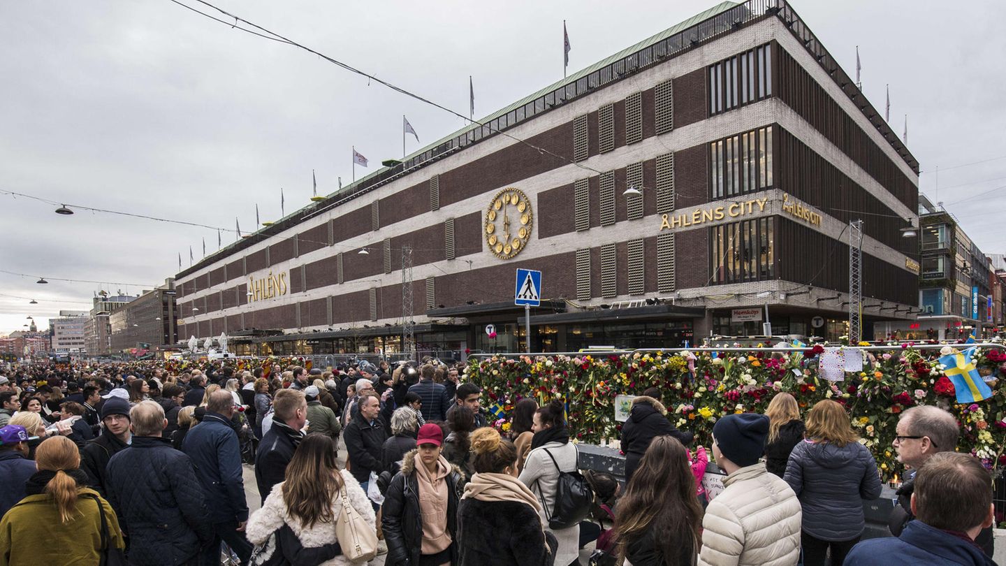 Passanten trauern vor dem Kaufhaus Ahlens City in Stockholm