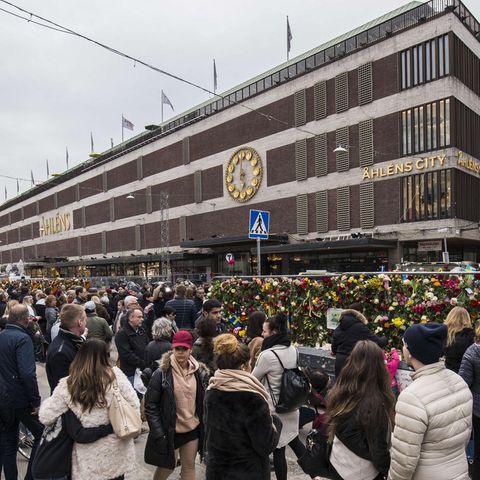 Passanten trauern vor dem Kaufhaus Ahlens City in Stockholm