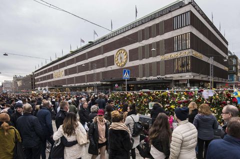 Passanten trauern vor dem Kaufhaus Ahlens City in Stockholm