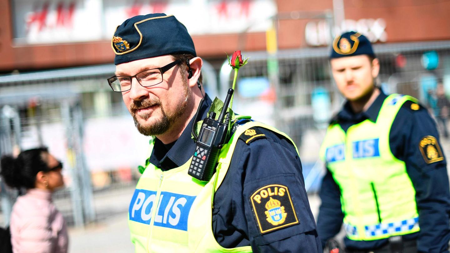 Polizisten in Stockholm tragen Rosen an der Uniform