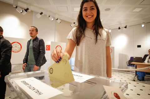 Eine junge Frau gibt in einem Wahlbüro in Warschau, Polen, ihren Stimmzettel zum Referendum der Türkei ab