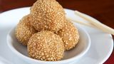 Sesambällchen aus China  Diese Süßigkeit besteht aus Reis und wird frittiert. Gefüllt werden die Bällchen mit Lotus-Pasta oder einer Paste aus süßen schwarzen Bohnen.