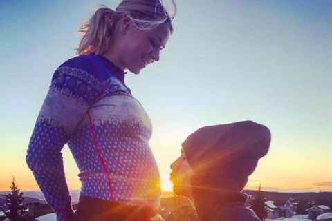 Felix Neureuther küsst den Babybauch seiner Partnerin Miriam Gössner