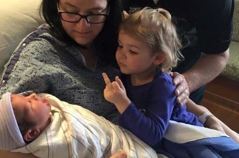 Mädchen zeigt einem Baby den Mittelfinger