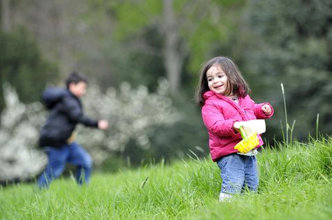 Zwei Kinder suchen auf einer Wiese Ostereier. Das Wetter an Ostern 2017 wird ungemütlich.