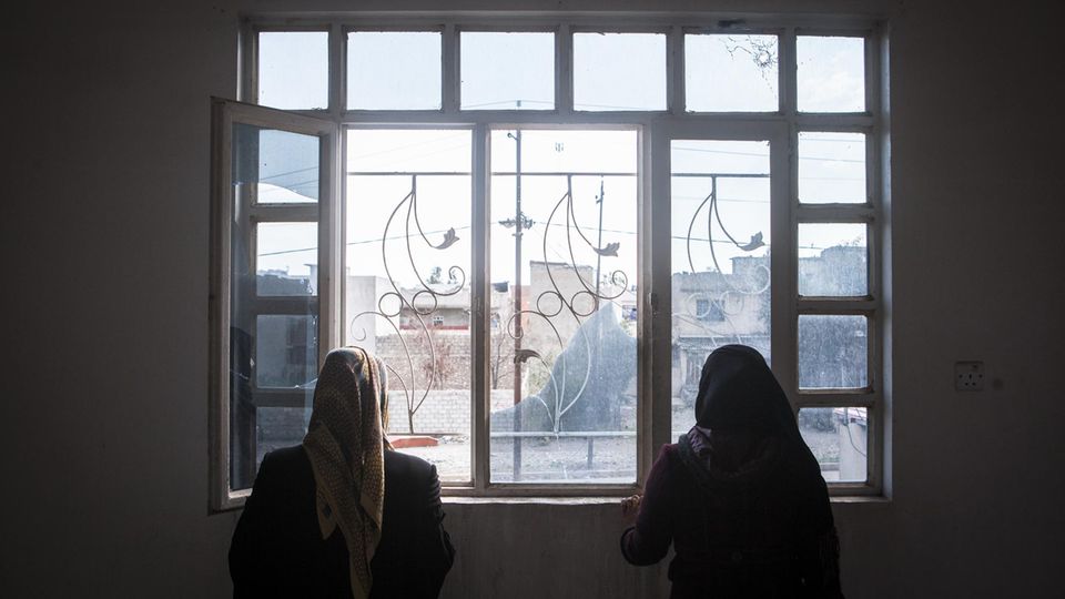 Samira und ihre Tochter Abla. Aus Angst vor Rache möchten sie unerkannt bleiben Zu sehen sind zwei Frauen, die aus einem Fenster gucken.