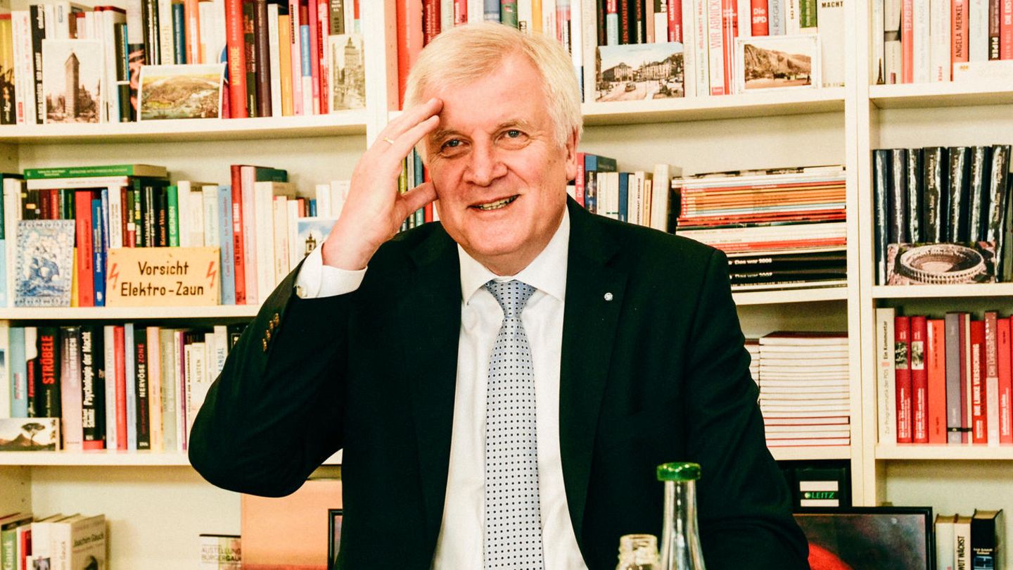 Zu sehen ist Horst Seehofer an einem Tisch mit Getränken und Gebäck. Er fasst sich amüsiert an den Kopf.