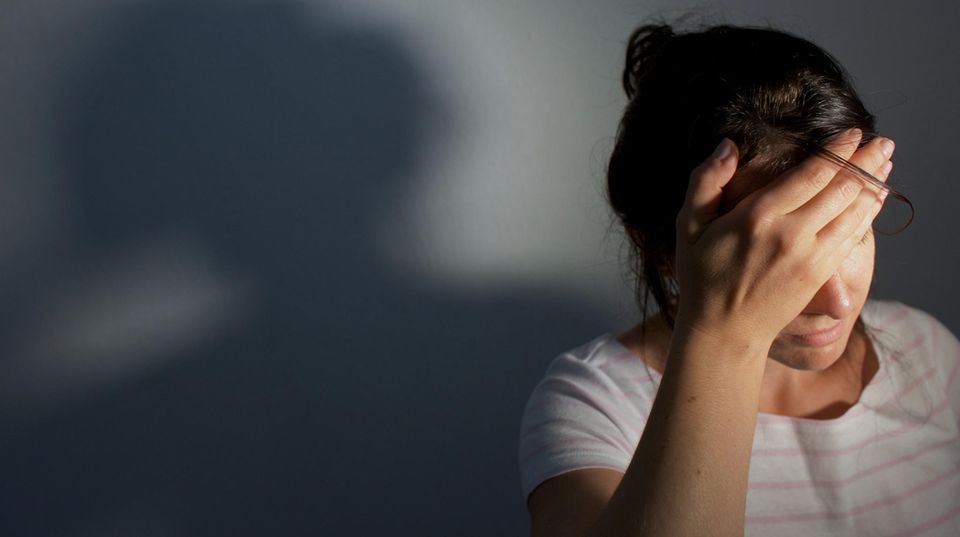 Frau hält sich vor Schmerz die Hand an den Kopf Frau hält sich vor Schmerz die Hand an den Kopf