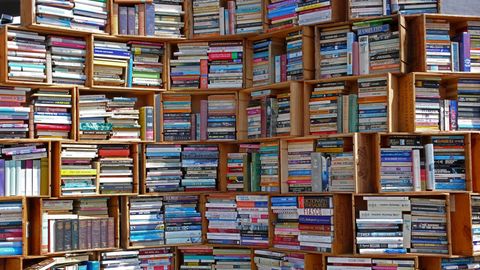 Zu sehen ist ein großes Bücherregal, aus Holzkisten gezimmert und voller Bücher.