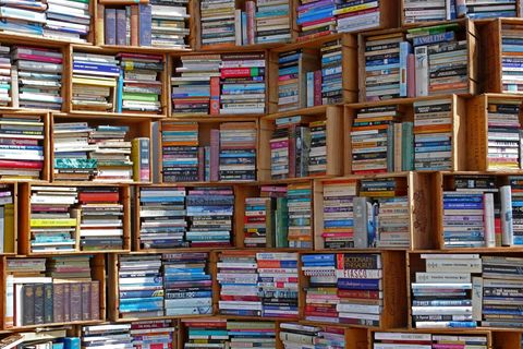 Zu sehen ist ein großes Bücherregal, aus Holzkisten gezimmert und voller Bücher.