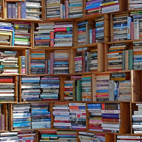 Zu sehen ist ein großes Bücherregal, aus Holzkisten gezimmert und voller Bücher.