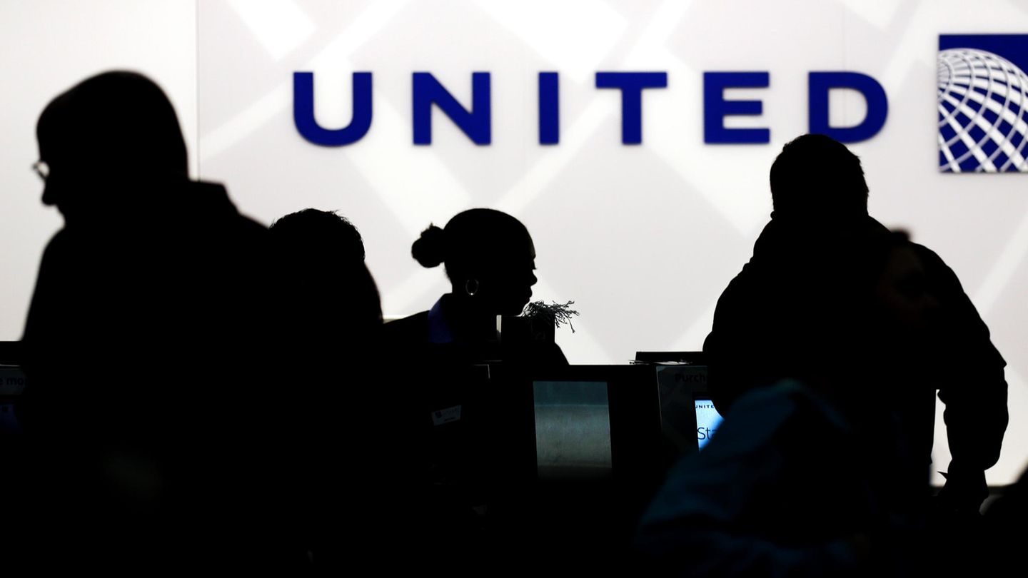 Vor einem Schalter von United Airlines zeichnen sich die dunklen Konturen von Flugpassagieren ab