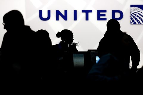 Vor einem Schalter von United Airlines zeichnen sich die dunklen Konturen von Flugpassagieren ab