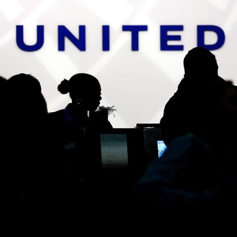 Vor einem Schalter von United Airlines zeichnen sich die dunklen Konturen von Flugpassagieren ab