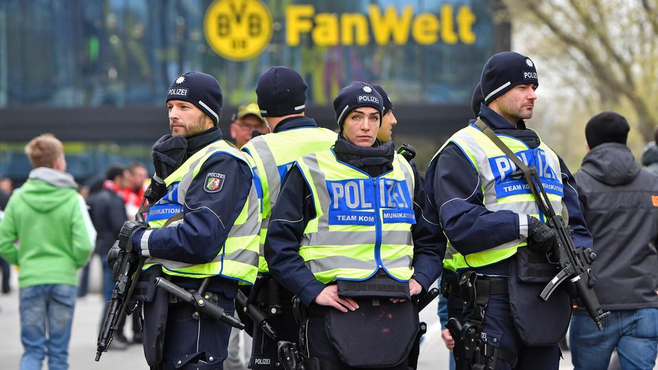 Fünf Polizistinnen und Polizisten stehen Rücken an Rücken vor dem Stadion von Borussia Dortmund