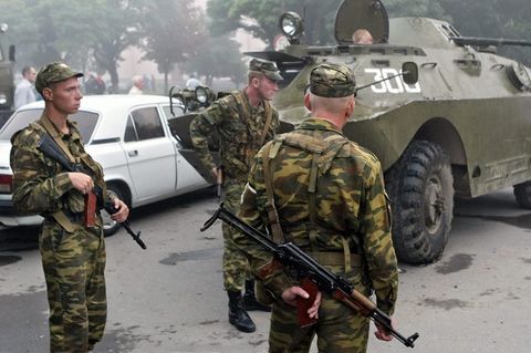 Russische Soldaten stehen am 1. September 2004 nahe der Grundschule in Beslan, in der sich das Geiseldrama ereignete