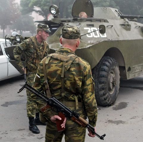 Russische Soldaten stehen am 1. September 2004 nahe der Grundschule in Beslan, in der sich das Geiseldrama ereignete