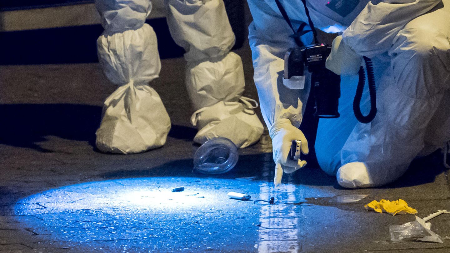 Zwei Polizeibeamte suchen am Tatort nach Spuren