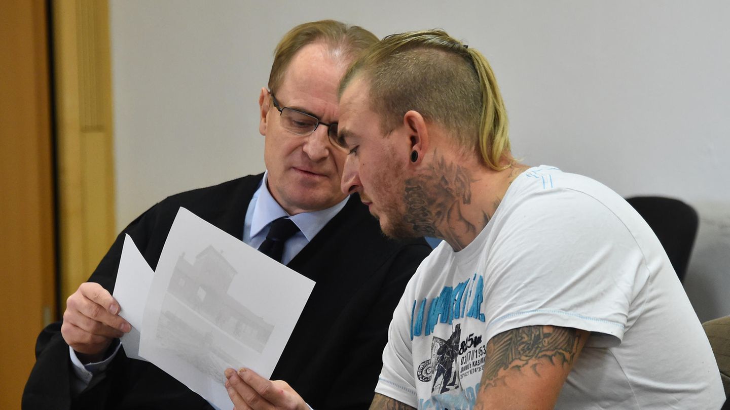 NPD-Politiker Marcel Zech (r.) bespricht sich mit seinem Anwalt im Gerichtssaal in Neuruppin