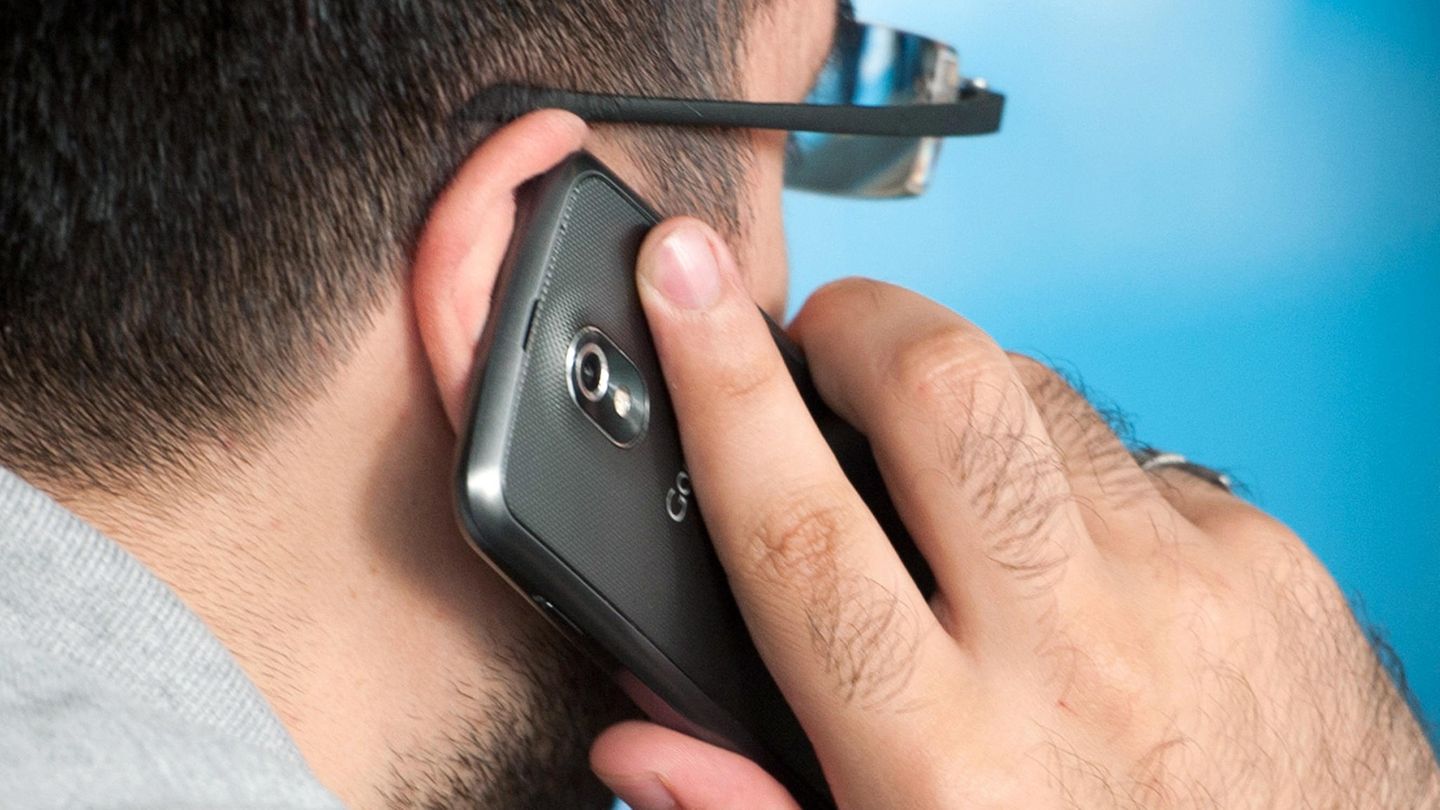 Ein Mann telefoniert mit einem Smartphone am Ohr.