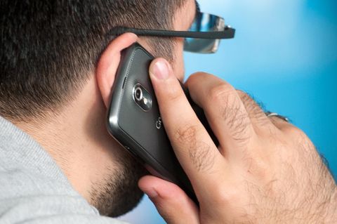 Ein Mann telefoniert mit einem Smartphone am Ohr.