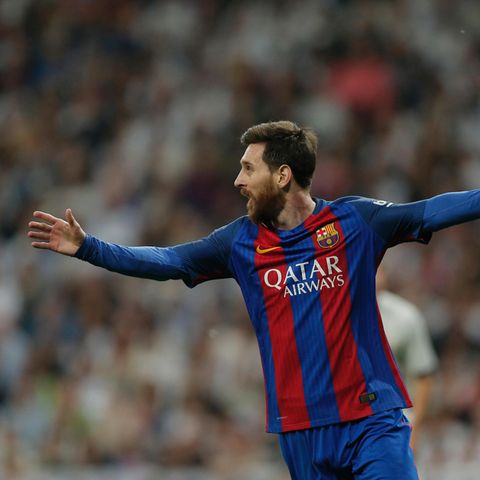 Lionel Messi läuft im rot-blau gestreiften Trikot des FC Barcelona mit ausgebreiteten Armen jubelnd über den Rasen