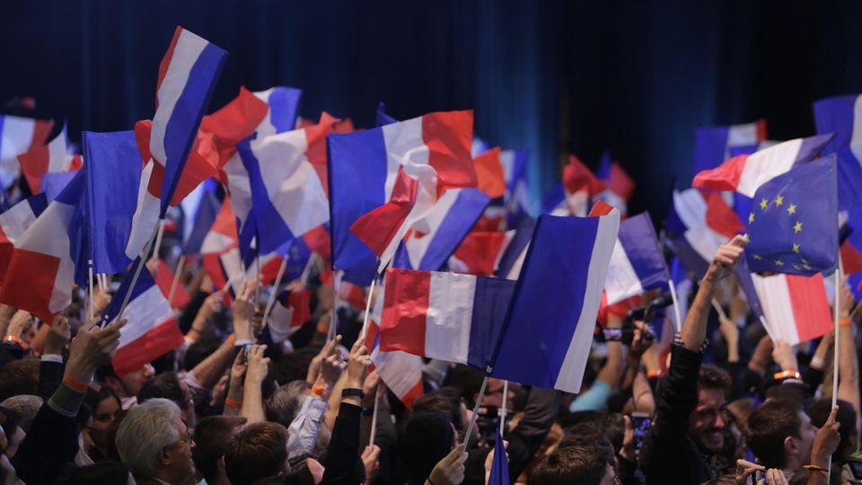 Anhänger des französischen Präsidentschaftskandidaten Emmanuel Macron schwenken französische Flaggen