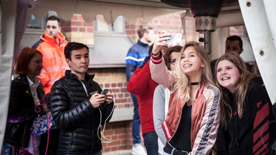 Lisa und Lena Eins der Zwillingsmädchen fotografiert sich mit einem Fan