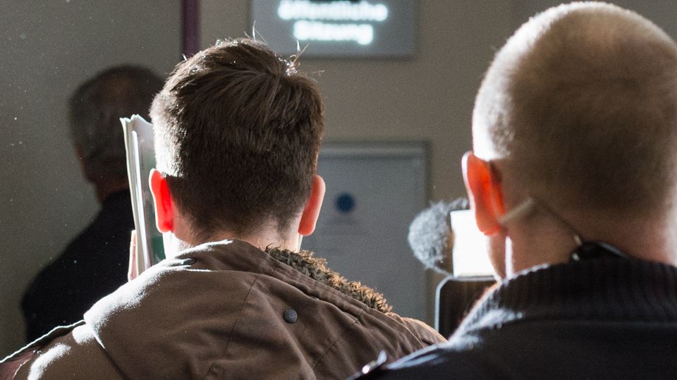 Einer der Angeklagten (l.) im Lübecker Missbrauchsprozess auf dem Weg in den Gerichtssaal