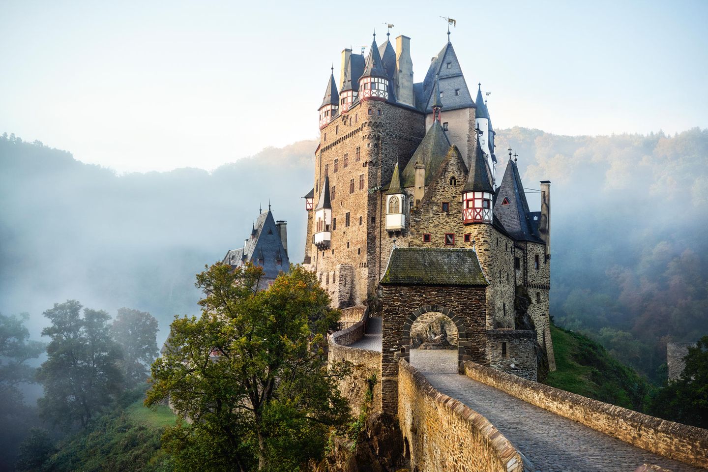 "Geo Epoche Panorama": Burg Eltz, Rheinland-Pfalz: Eine Festung, viele Herren Seit über 850 Jahren ist Burg Eltz im Besitz der gleichen Familie. Im Lauf der Zeit schafft das Geschlecht eine Bastion, die so vielgestaltig ist wie kaum eine andere in Deutschland. Denn im 13. Jahrhundert wird sie unter drei Brüdern aufgeteilt, um Erbstreitigkeiten zu vermeiden – woraufhin jede der drei Linien ihren Wohnbereich nach eigenen Vorstellungen ausbaut, mit jeweils eigenen Gebäuden, Türmen und Erkern. Burg Eltz, Rheinland-Pfalz: Eine Festung, viele Herren Seit über 850 Jahren ist Burg Eltz im Besitz der gleichen Familie. Im Lauf der Zeit schafft das Geschlecht eine Bastion, die so vielgestaltig ist wie kaum eine andere in Deutschland. Denn im 13. Jahrhundert wird sie unter drei Brüdern aufgeteilt, um Erbstreitigkeiten zu vermeiden – woraufhin jede der drei Linien ihren Wohnbereich nach eigenen Vorstellungen ausbaut, mit jeweils eigenen Gebäuden, Türmen und Erkern.