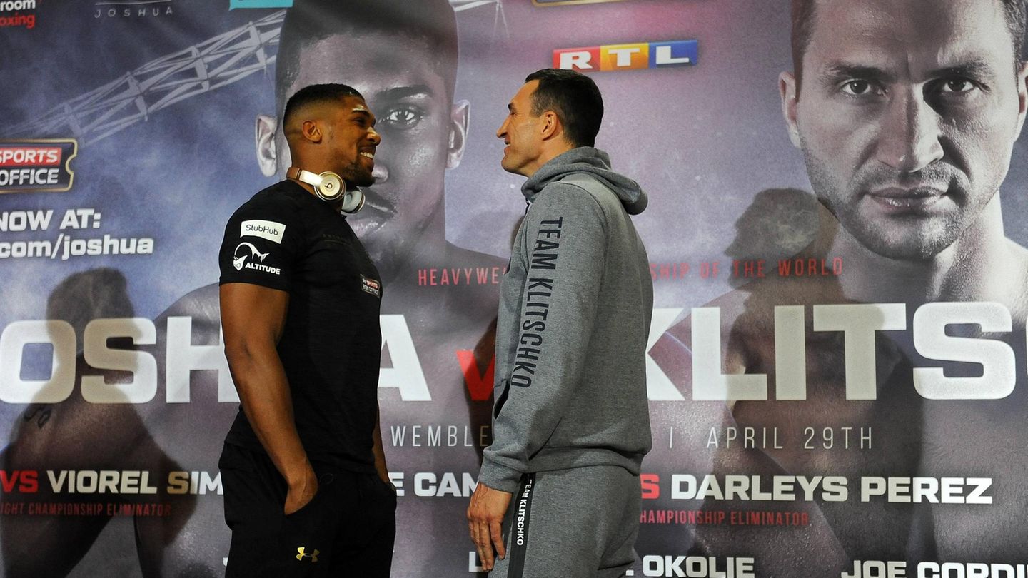 Anthony Joshua und Wladimir Klitschko stehen sich auf der Pressekonferenz gegenüber und müssen lachen.