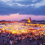 Marrakesch in Marokko: Verwinkelte Gassen, duftende Tajine, bunte Basare und blühende Gärten  Wenn wir, wie Ray Bradbury behauptete, wegen der Romantik, der Architektur und aus dem Wunsch heraus reisen, uns zu verirren, dann ist Marrakesch ein Volltreffer. Die legendäre "Rote Stadt" besteht aus Mauern aus Lehm und Sandstein, die abends erstrahlen, als wären sie mit der untergehenden Sonne verkabelt. Im Herzen der Anlage liegt die Medina, die Altstadt, die sich im Lauf eines Jahrtausends zu einem riesigen Labyrinth ausgewachsen hat, das geradezu danach schreit, gemeinsam erkundet zu werden.