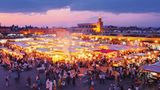 Marrakesch in Marokko: Verwinkelte Gassen, duftende Tajine, bunte Basare und blühende Gärten  Wenn wir, wie Ray Bradbury behauptete, wegen der Romantik, der Architektur und aus dem Wunsch heraus reisen, uns zu verirren, dann ist Marrakesch ein Volltreffer. Die legendäre "Rote Stadt" besteht aus Mauern aus Lehm und Sandstein, die abends erstrahlen, als wären sie mit der untergehenden Sonne verkabelt. Im Herzen der Anlage liegt die Medina, die Altstadt, die sich im Lauf eines Jahrtausends zu einem riesigen Labyrinth ausgewachsen hat, das geradezu danach schreit, gemeinsam erkundet zu werden.