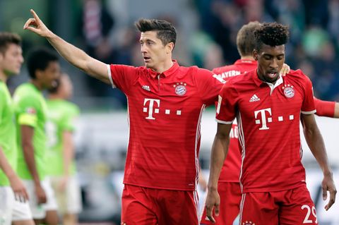 Robert Lewandowski und Kingsley Coman gehen kurz nach einem Tor Lewandowskis Arm in Arm über den Fußballplatz
