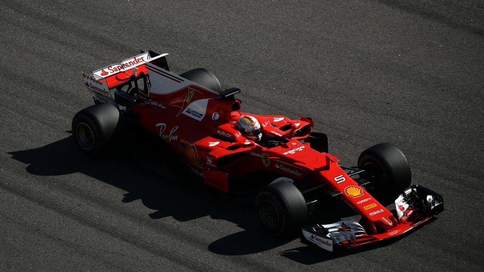 Der rote Ferrari von Sebstian Vettel rast über den dunkelgrauen Asphalt der Formel 1 Rennstrecke in Sotschi