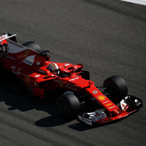 Der rote Ferrari von Sebstian Vettel rast über den dunkelgrauen Asphalt der Formel 1 Rennstrecke in Sotschi