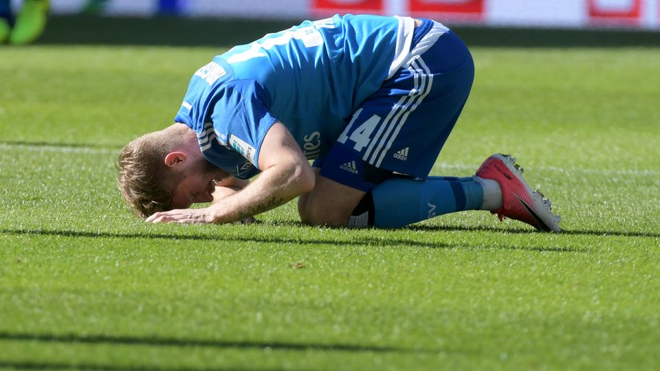 aaron Hunt vom HSV kniet auf dem Rasen und berührt mit der Stirn den Boden