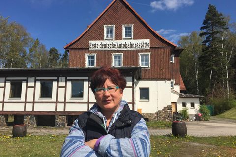 Über einen Zaun hinweg verkauft Christina Wagner ihre Bratwürste an der Autobahnraststätte