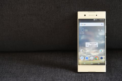 Das Sony Xperia XA1 steht aufrecht auf einer Couch